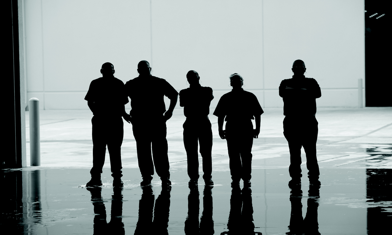 Standing Interns Silhouetted Under Overhead Door